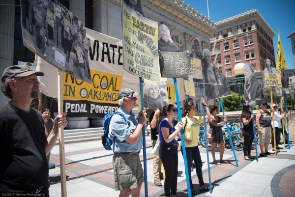 Demonstrators holding photo blowups of Oakland coal resistance fighters, created by David Solnit and Brooke Anderson Photo: Brooke Anderson