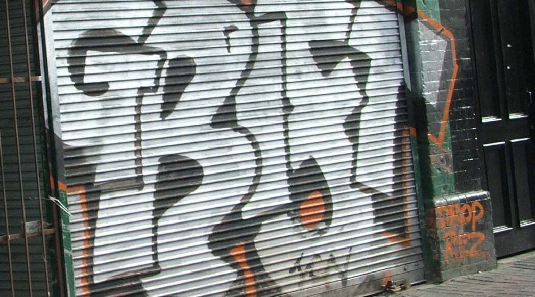 "Grift" graffitied on a merchant's roll-down door. Image credit: jaqian (Flickr) CC By 2.0, https://www.flickr.com/photos/jaqian/24000174/.