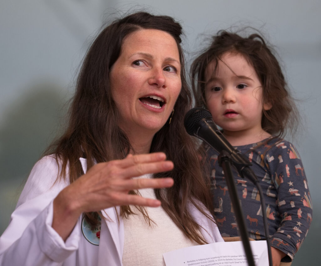 Berkeley Parent Sarah Berg at the mic, Berkeley Rally, 2026-09-15. Photo Credit Leon Kunstenaar.